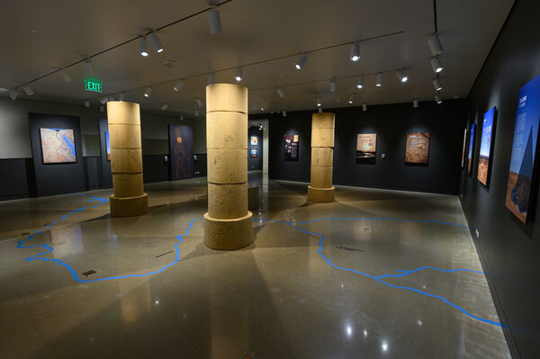 An exhibit room with low lighting and columns