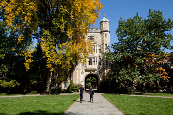 People walking in the Law Quad courtyard in early fall as the leaves begin to change
