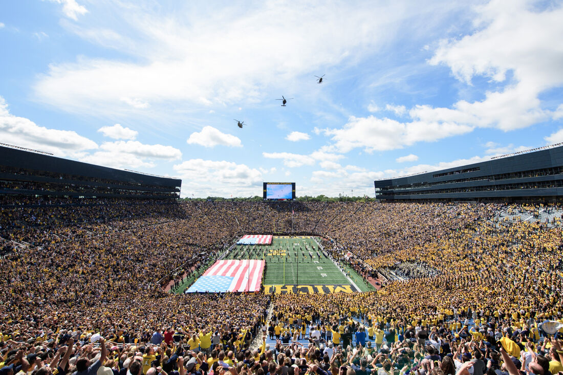 A full stadium with large American flags on the field