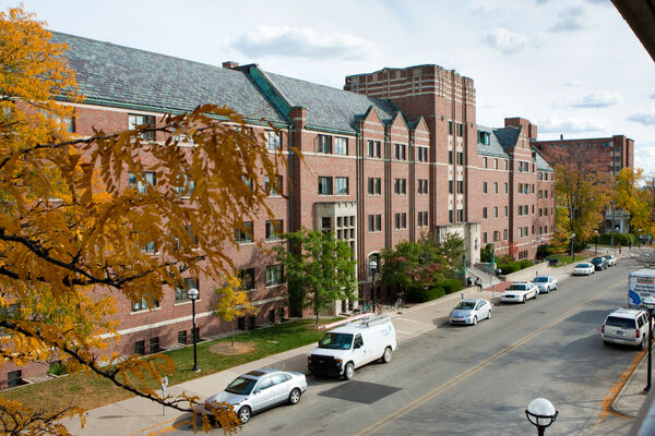 The brick exterior of Mosher-Jordan Hall with trees turning colors in fall