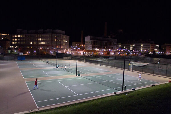People playing tennis at night