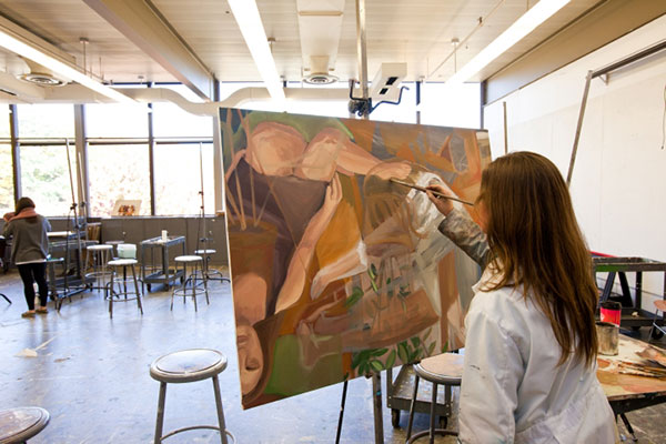 A student working on a painting in an art studio