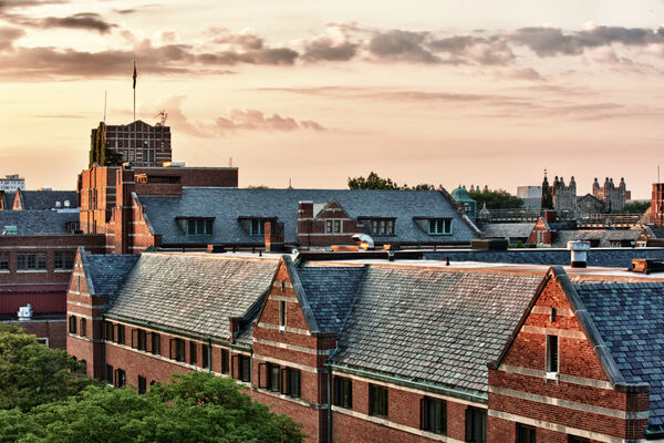 A view of the sun setting over the roof of the West Quad and the Union