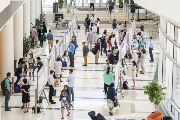 An interior atrium of Medical School filled with people at a poster presentation